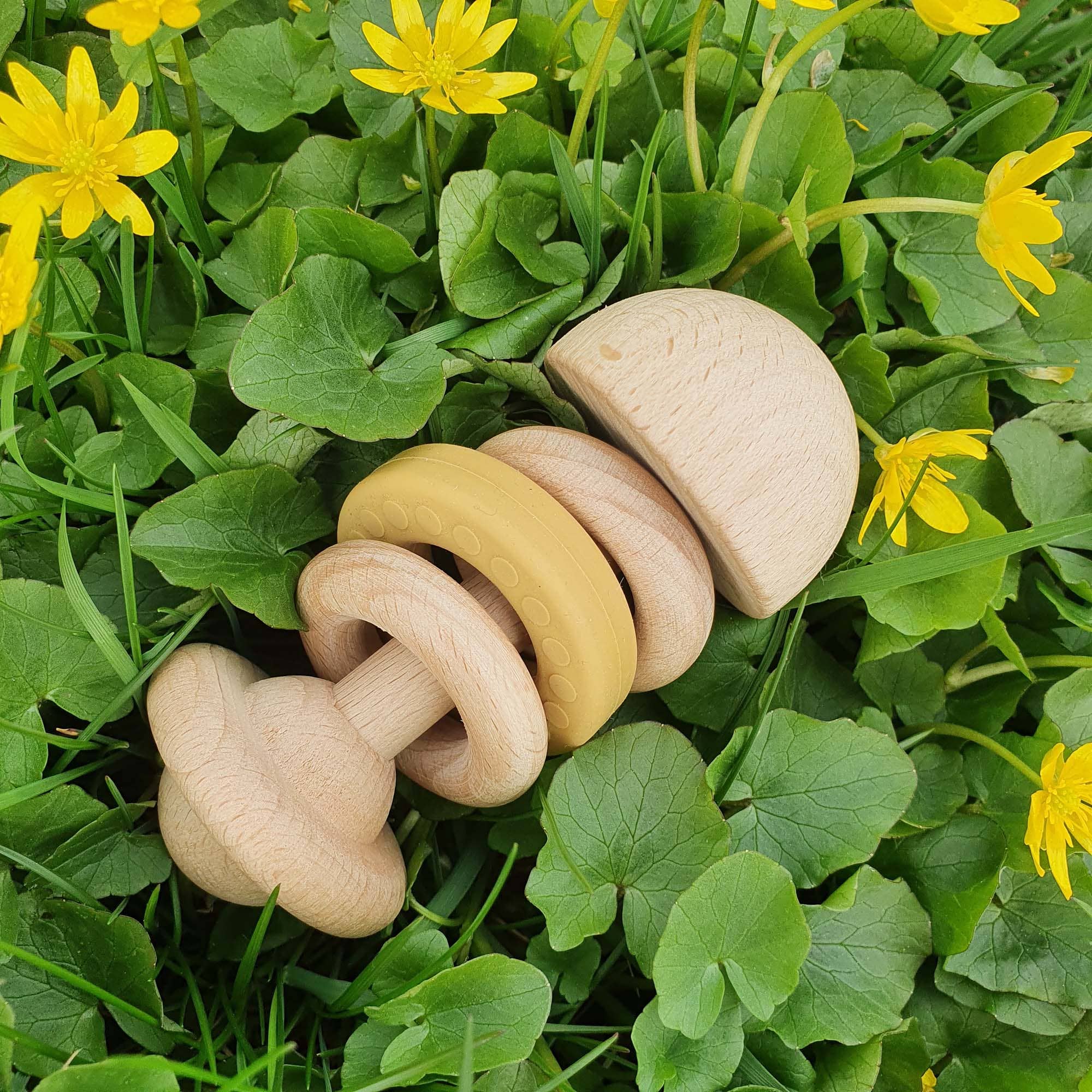 Baby rangle i træ med okkerfarvet silikonsring